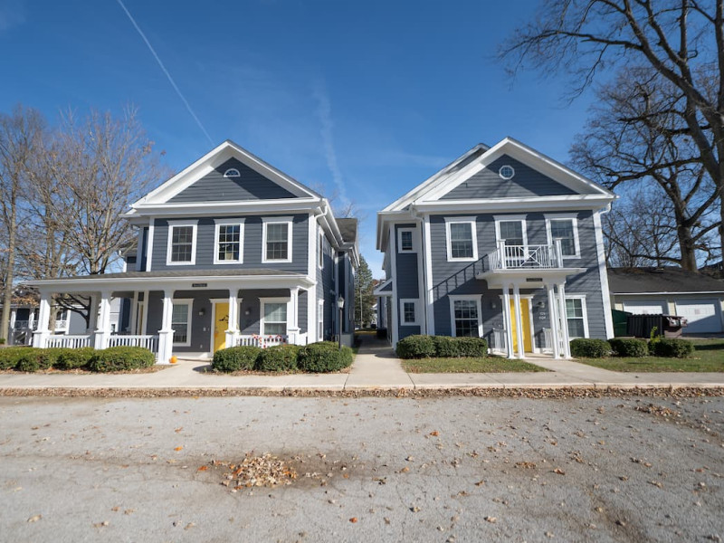 Two blue duplexes with yellow doors and white railings