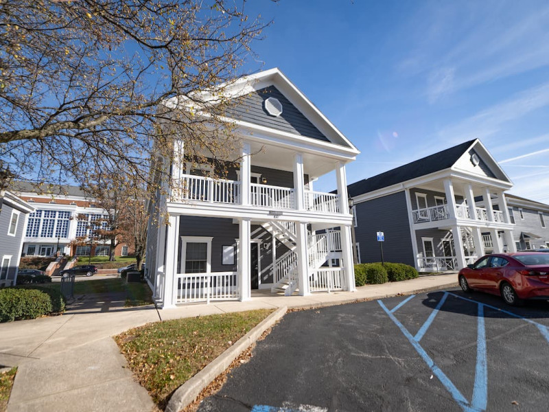 Two-story blue duplexes with exterior stairs and porches