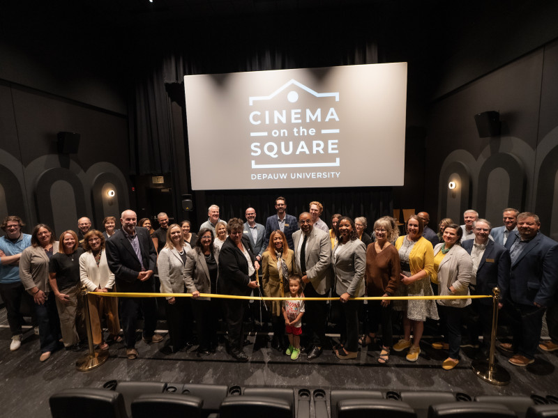CInema Project partners standing at the ribbon cutting inside of the theater