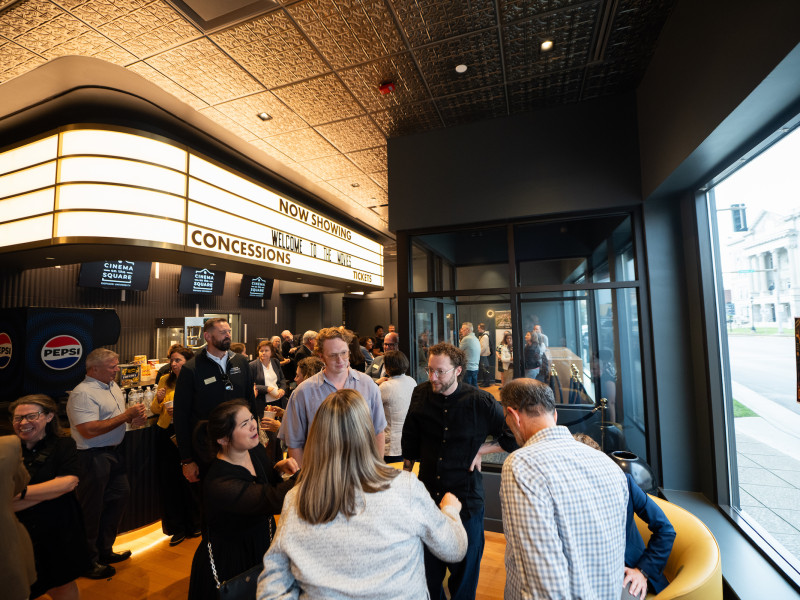 Patrons and project partners chatting at the box office for the cinema 