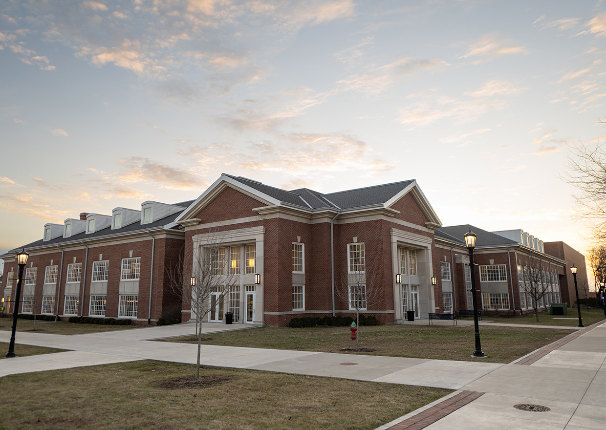 Exterior of the Lilly Center from the corner entrance with the sun setting behind it.