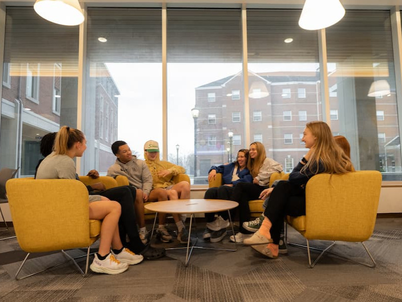 Students socializing in a modern residence hall lounge
