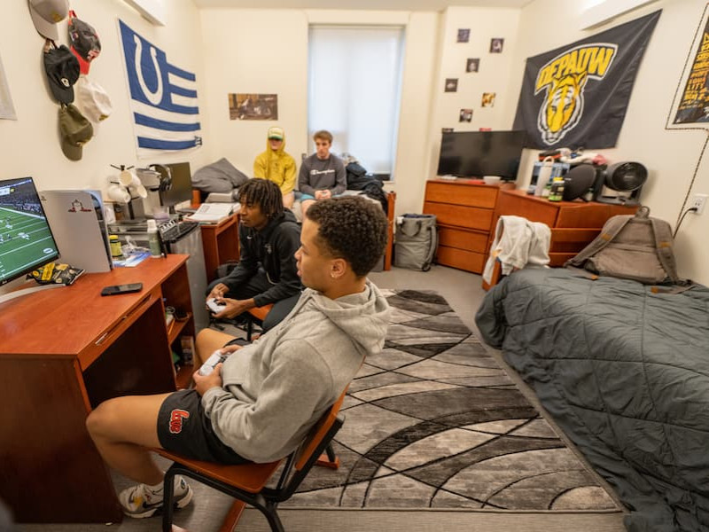 Students playing a video game in a residence hall room
