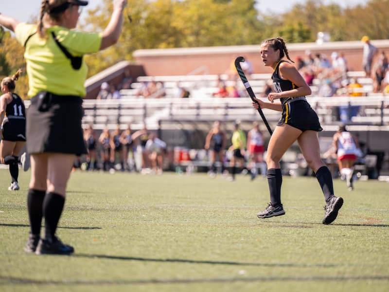 Field hockey player in action on a sunny campus field