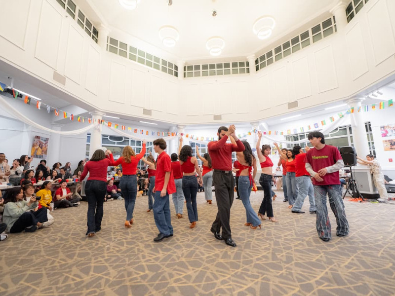 People dancing in a large, bright indoor hall.