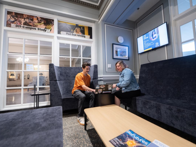 An advisor meeting with a student in a campus center.