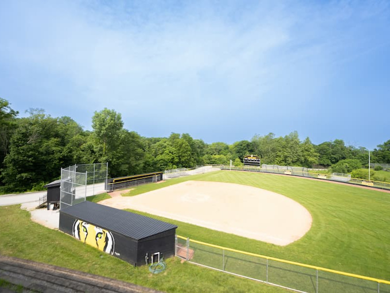 An outdoor university softball field on a sunny day