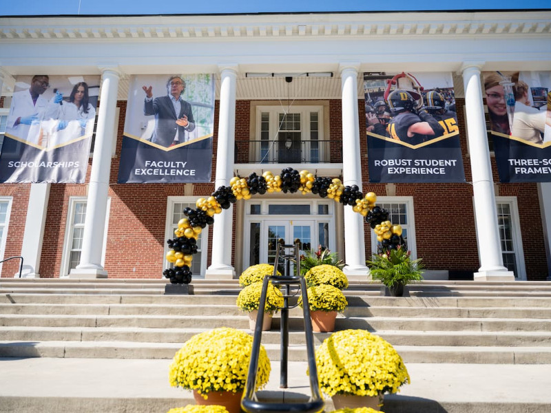A decorated university building entrance with large campaign banners.