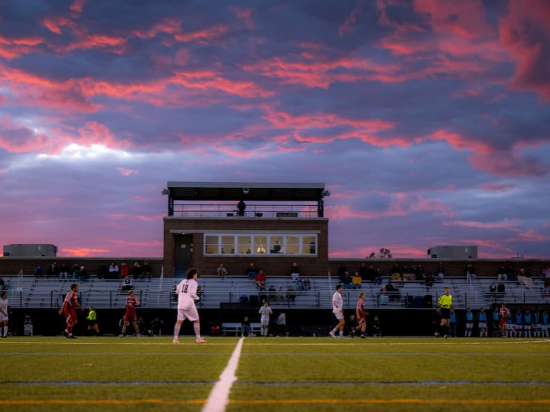 Soccer match at stadium during a dramatic sunset