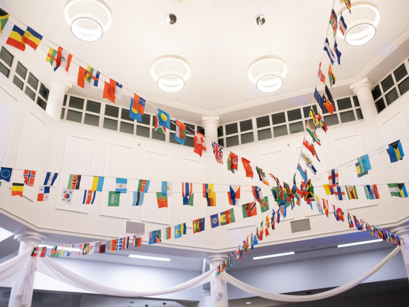 International flags strung across a high-ceilinged indoor atrium.