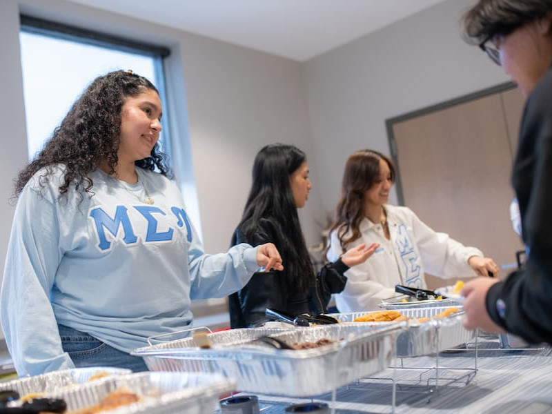 Students serving food at a Taste Around the World event
