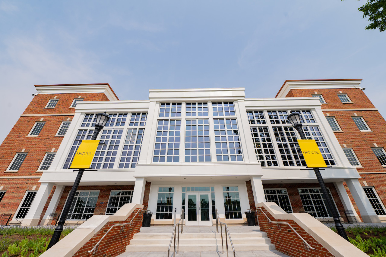 Back exterior of Roy O. Library building shot from the bottom of the entrance steps highlighting a large wall of windows.