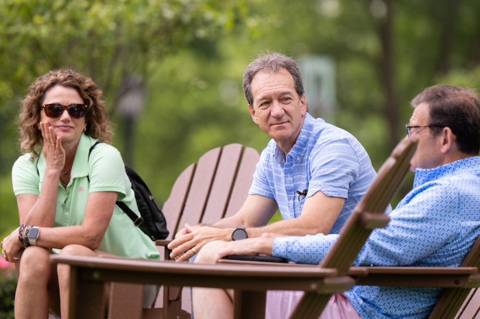 Alumni visiting while sitting in chairs