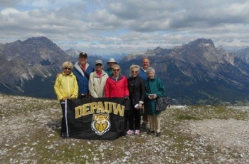 The Kanters with a DePauw flag in the mountains