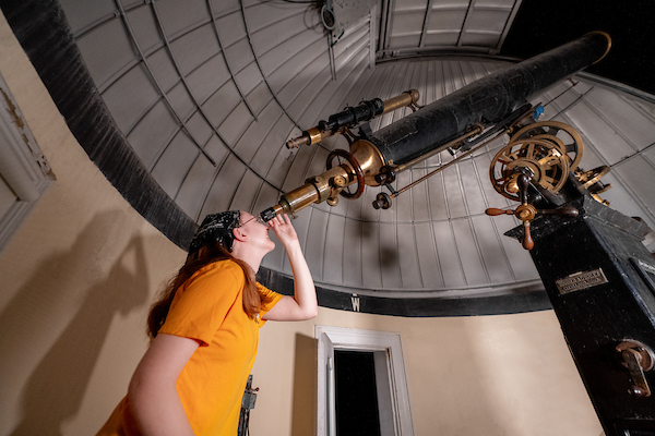 Student looking through a telescope at McKim
