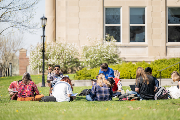 Students sitting in the grass during an outside class