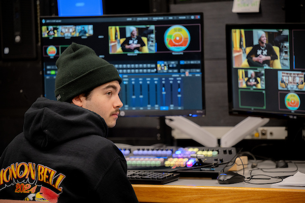 Student in front of a screen in a recording studio